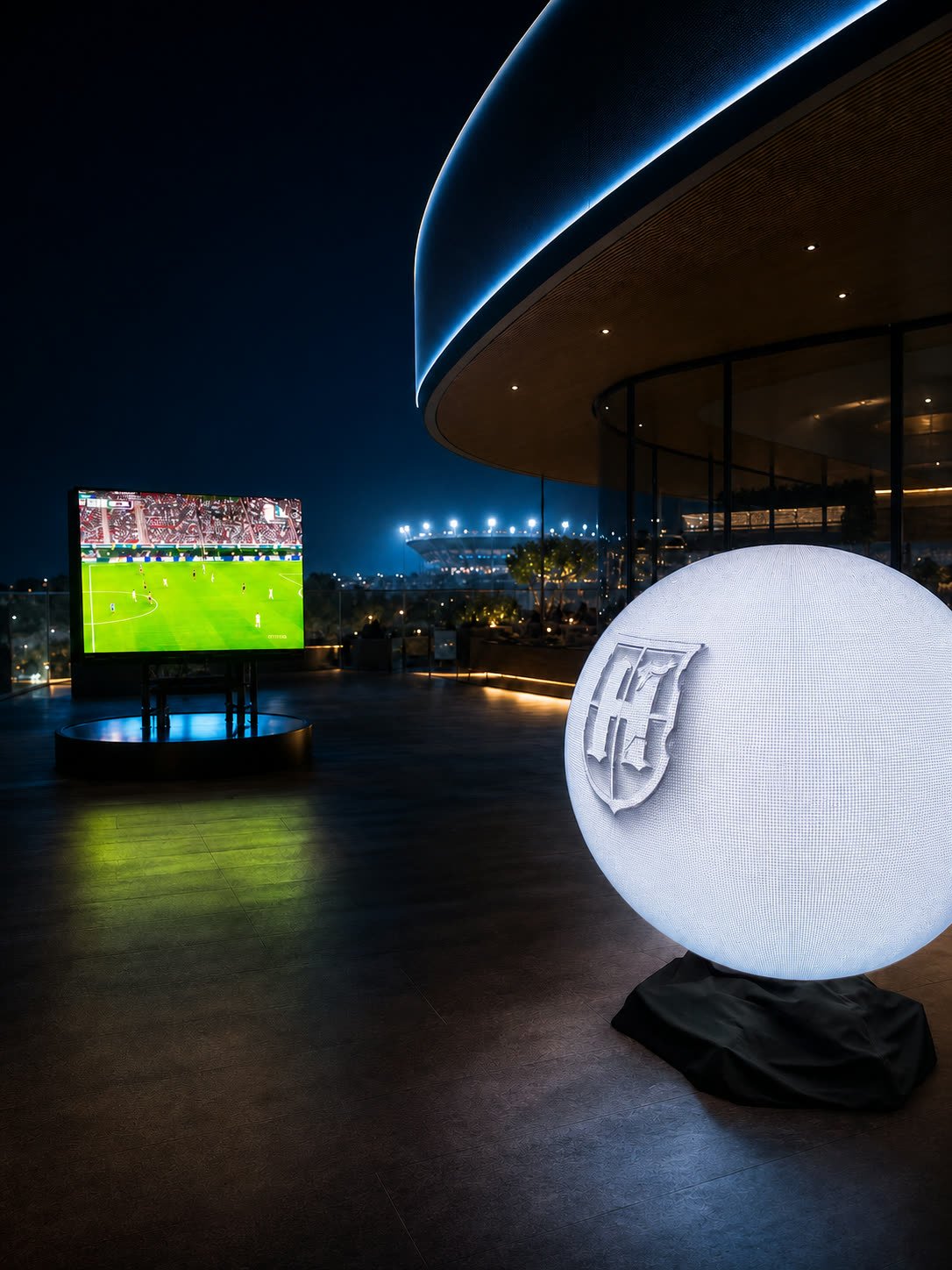 Esfera LED y pantalla exterior en terraza de evento nocturno